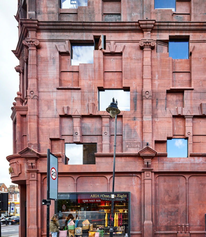 Red stone building with very reflective windows on Upper Street